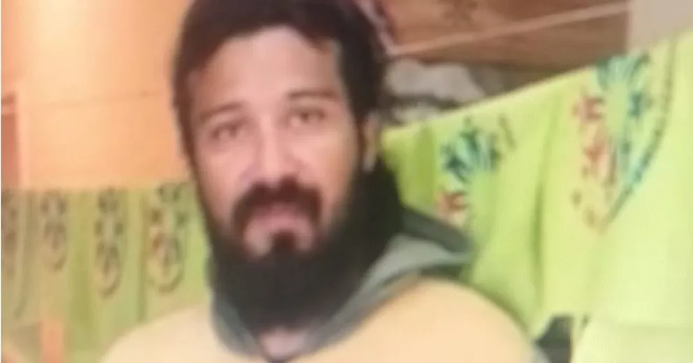 Es delgado, tiene el cabello largo ondulado de color negro.