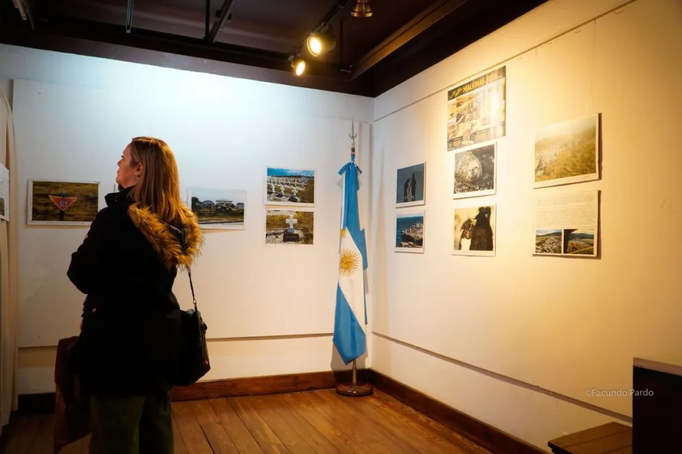 Muestra fotográfica sobre Malvinas en el Museo de la Patagonia; la bandera argentina junto a las imágenes de las islas (foto: Facundo Pardo).