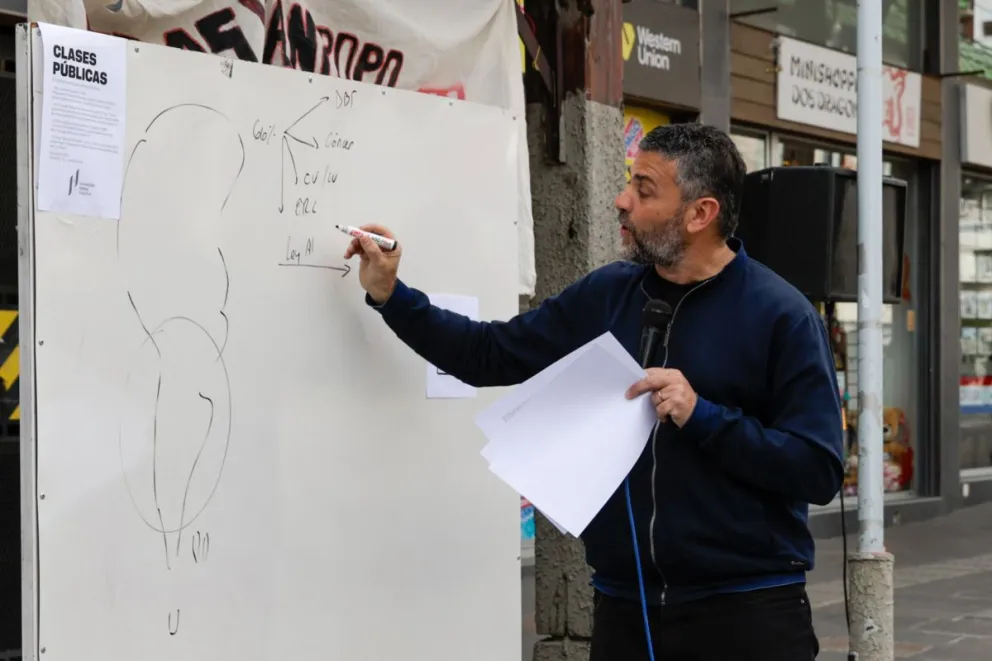 Germán Guaresti, director de la carrera de Medicina al momento de dictar una clase abierta en defensa de la Universidad Pública sobre calle Mitre. Foto de Eugenia Neme.