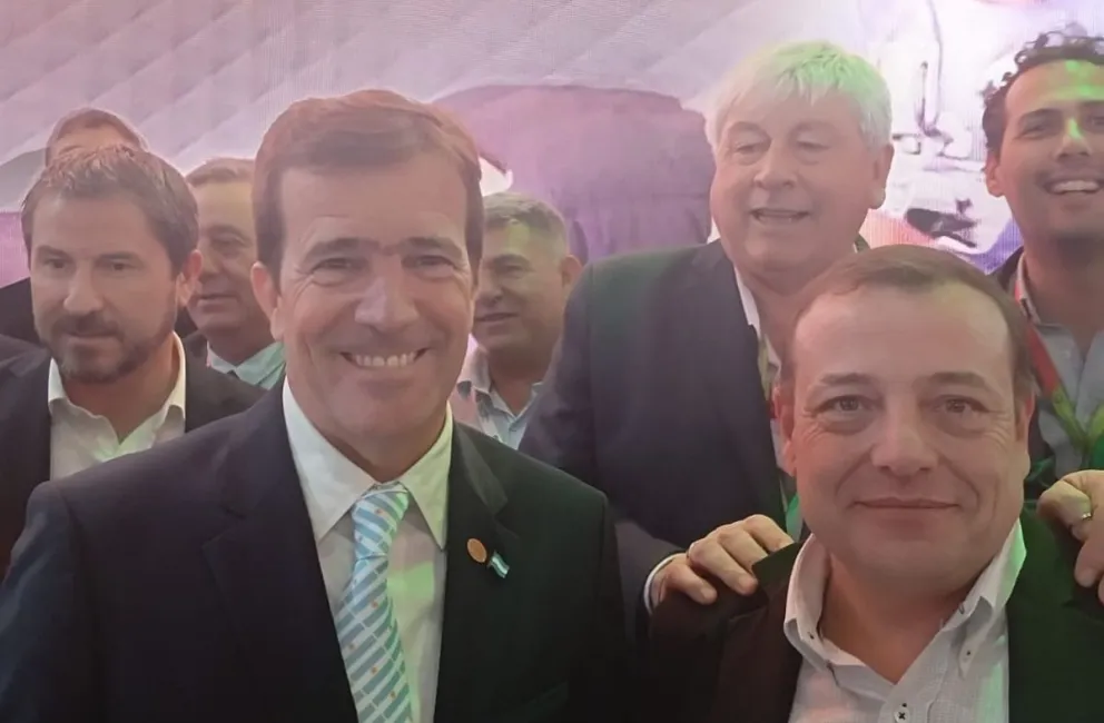 El presidente de la FIT, Andrés Deyá junto a Cortes y Ferrari, junto al stand de Bariloche.