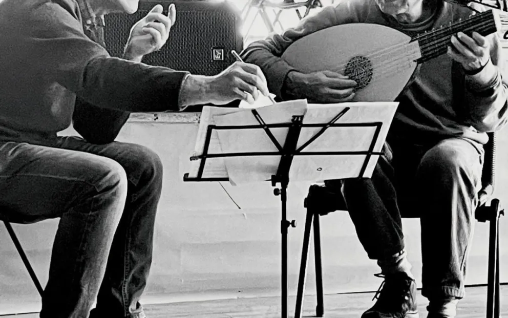 Con el laúd en primer plano.