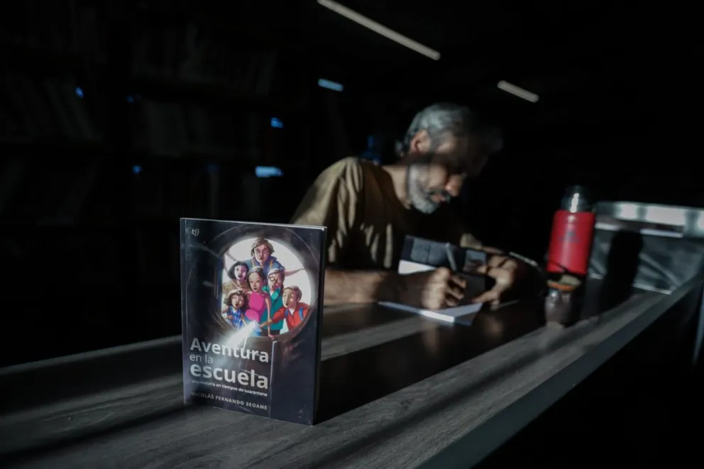 Delante, el libro; detrás, su autor, firmando un ejemplar (fotos tomadas por Verónica Manzanares, cedidas por Nicolás Seoane).