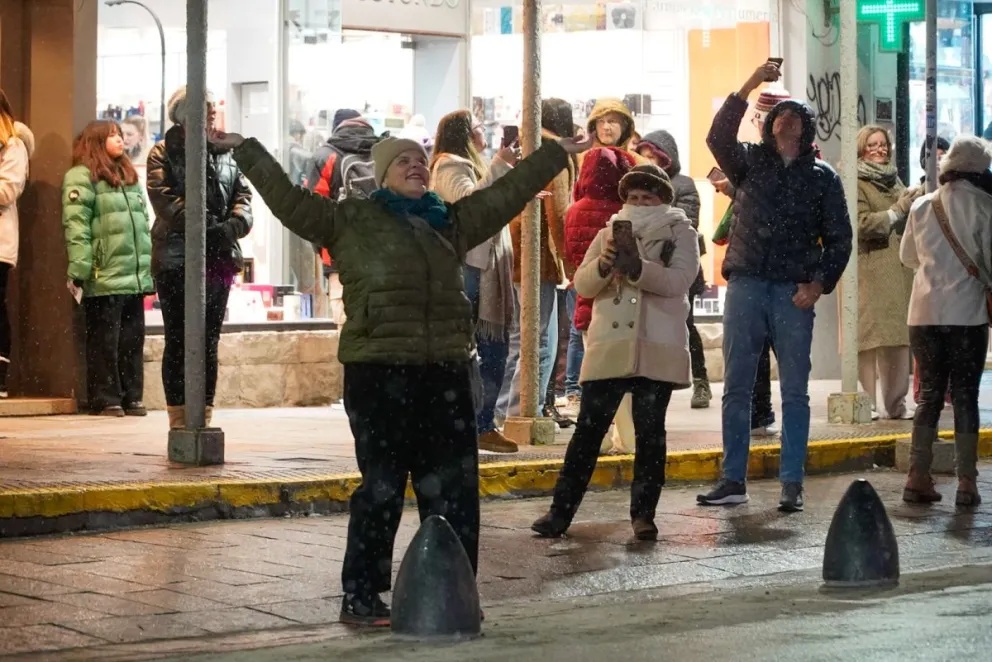 Los turistas se entusiasmaron con la nevisca que cayó en el centro de Bariloche. Fotos: Facundo Pardo. 
