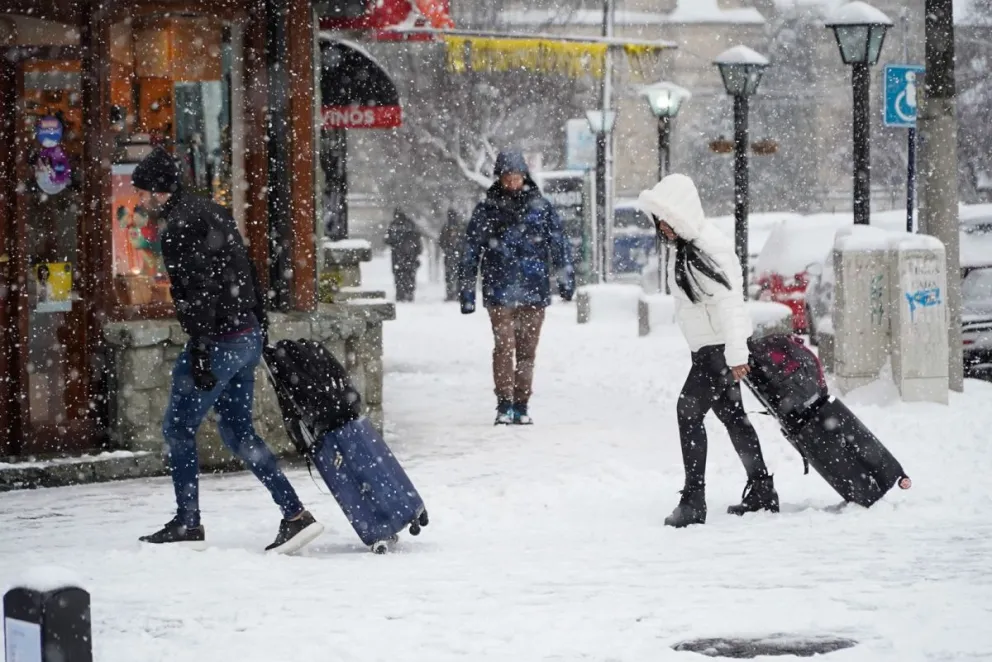 Los turistas bajo una de las nevadas pasadas en la ciudad. Foto Euge Neme 